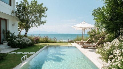 Naklejka premium Beautiful view of a pool overlooking the ocean on a sunny day near a beach house