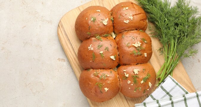 Fresh buns with garlic and dill on light table, flat lay. Space for text