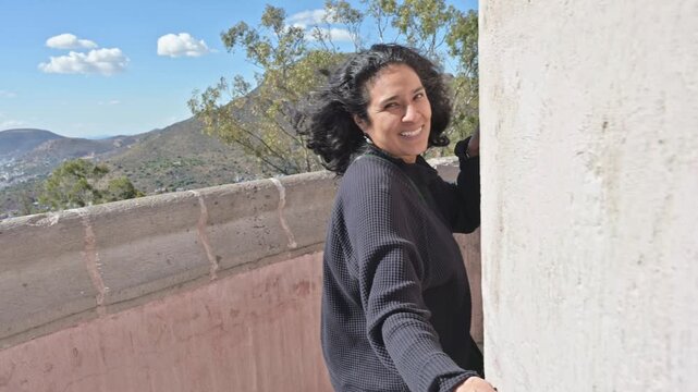Smiling Mature Tourist Enjoying the Breeze by Cristo Rey Monument