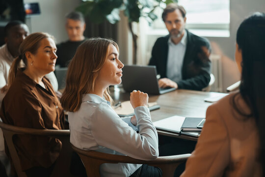 Team of corporate professionals attending group meeting at office