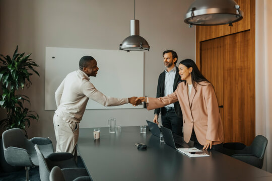 Smiling businesswoman congratulating candidate after interview in meeting room