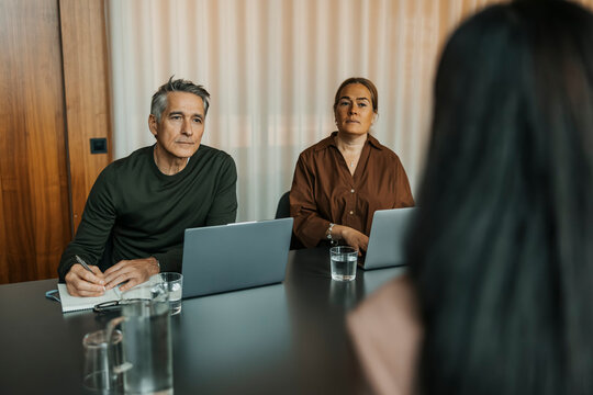 Male and female managers listening to candidate giving interview at office