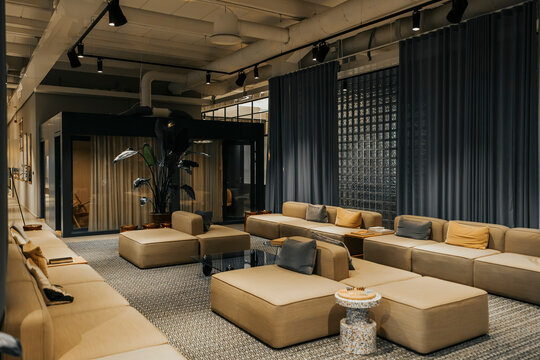 Sofas and couches arranged in illuminated lobby of modern office