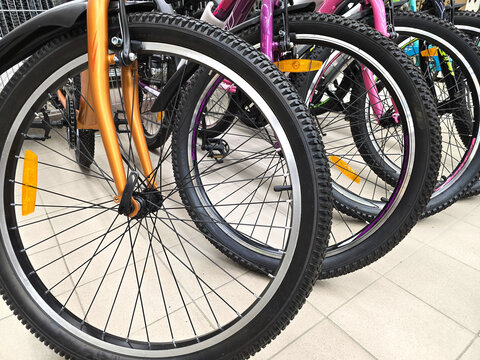A bike shop displays rows of new bicycles. A close-up of the wheels.