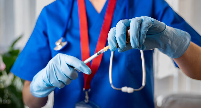 Nurse reloading syringe with vaccine - Healthcare worker preparing vaccination dose - Immunization and public health concept