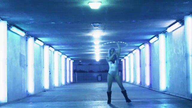 A regular footage of a hula hoop performer woman in an underground