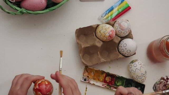 Happy smiling little girls and boy, kids cracking painted Easter eggs, having fun against yellow background. Concept of Easter holiday, celebration, traditions, childhood, happiness, family