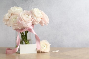 Beautiful flowers and blank card on wooden table. Space for text