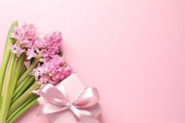 Naklejka premium Beautiful hyacinth flowers and gift box on pink background, flat lay. Space for text