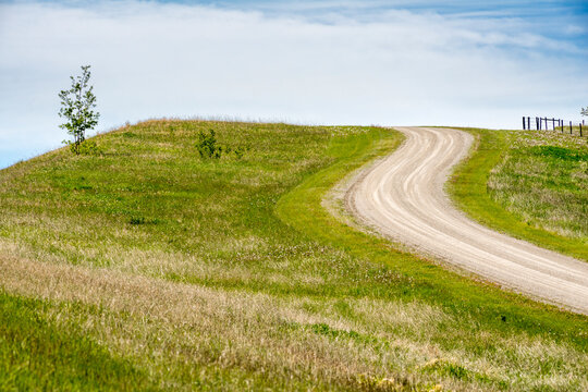 Canada, Alberta, Turner Valley.  Dirt road winding up a hill in the Rocky Mountain foothills.