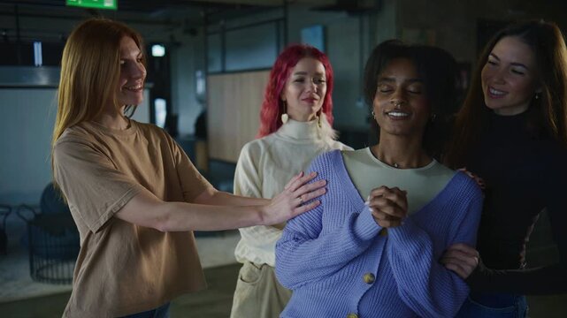 Four women stand together in a room, engaged in a psychology session. They are focused and supportive as they interact with each other.