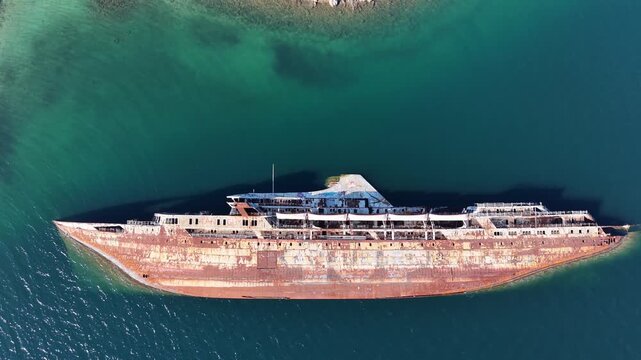 Aerial view of abandoned shipwreck MS Mediterranean Sky rusting in shallow turquoise water, Greece
