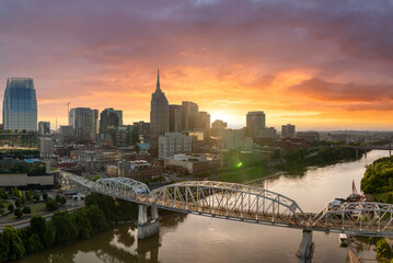 Downtown district of Nashville city in Tennessee, USA. Modern metropolitan area with riverfront, bridge and sunset horizon.