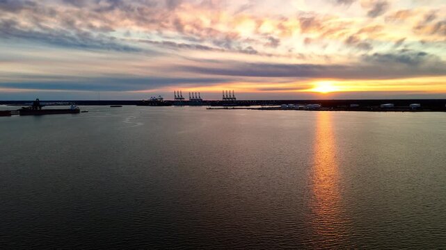 Dramatic sunset over the Elizabeth River industrial harbor and Norfolk Virginia skyline at golden hour
