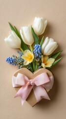 Obraz premium White tulip bouquet and spring gift heart box with pink bow on beige background