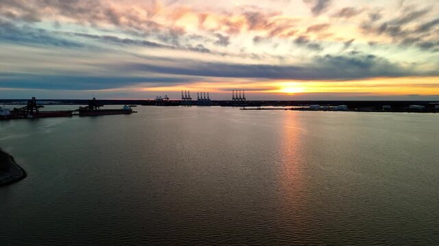 Dramatic sunset over the Elizabeth River industrial harbor and Norfolk Virginia skyline at golden hour