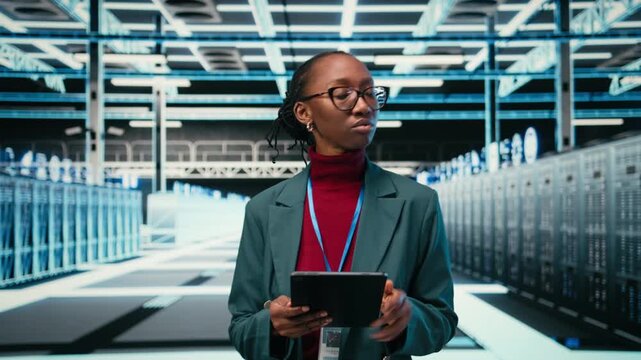 Female engineer walks in data center, using tablet and AR tech to monitor error logs, debugging systems. African american woman in server hub running diagnostics on blue wireframe mesh rigs, camera A