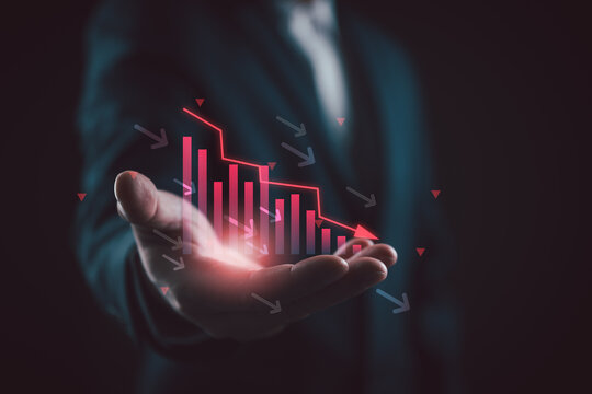 Businessman holding declining financial chart with red downward arrow, economic crisis and business loss concept, negative growth trend, stock market drop, revenue decrease, risk management strategy.