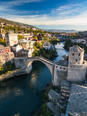 Naklejka premium Vertical aerial 4K view of the historic Stari Most bridge and Mostar old town at sunrise, Bosnia and Herzegovina