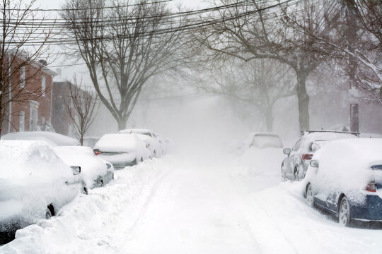 Severe winter snowstorm burying cars on Brighton Massachusetts street
