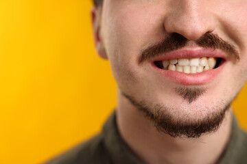 Obraz premium Man with mustache on orange background, closeup. Space for text