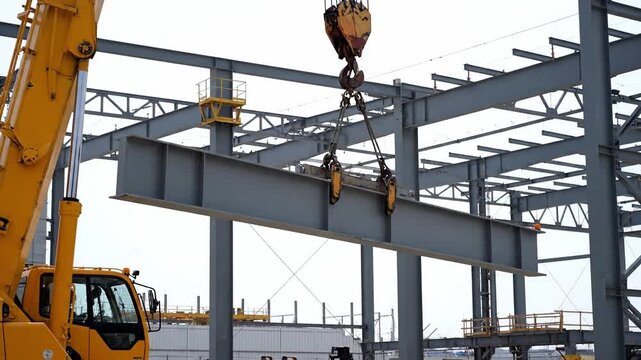 Heavy I beam Lifted by a Large Crane During Steel Frame Building Construction