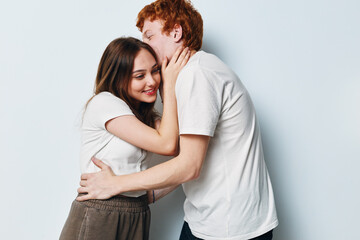 Couple, affection and love with young man and woman hugging and kissing on cheek for romance and relationship in casual clothes with white background indoors.