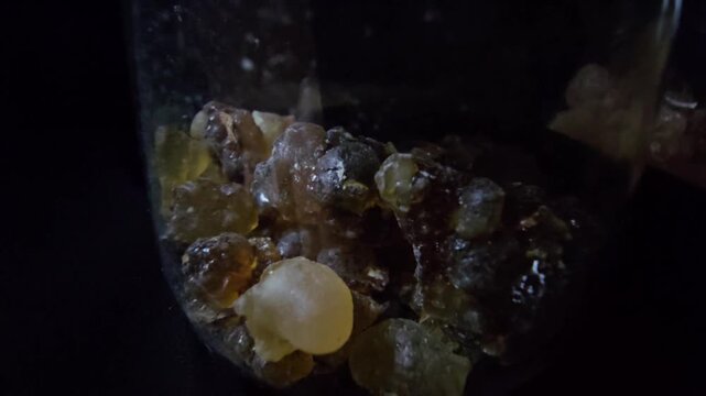 Macro video of Frankincense resin over a black background. Sharp focus on textures and amber colors, perfect for organic and wellness visuals.