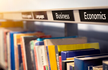 Naklejka premium Business and economics books. Educational subject textbooks in school library financial section.
