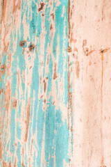 Fototapeta premium Peeling teal and beige paint on rustic wood background