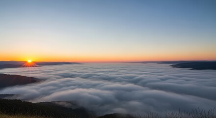 Fototapeta premium Radiant sunrise with a brilliant sunburst over a vast, calm sea of clouds filling a mountain basin.