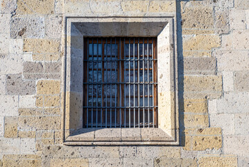 Fototapeta premium Architectural Stone Wall with Detailed Window and Iron Bars Exterior