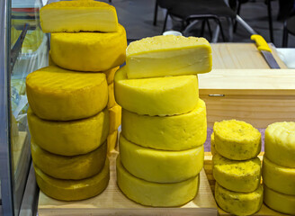 Stack of organic homemade cheese sold outside on local market stall