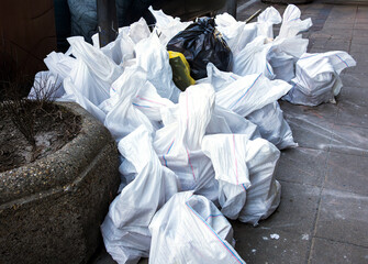 Large pile of plastic garbage bags outside on city street