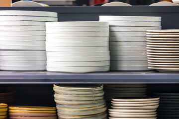 Empty ceramic plates stack inside shop interior on shelf