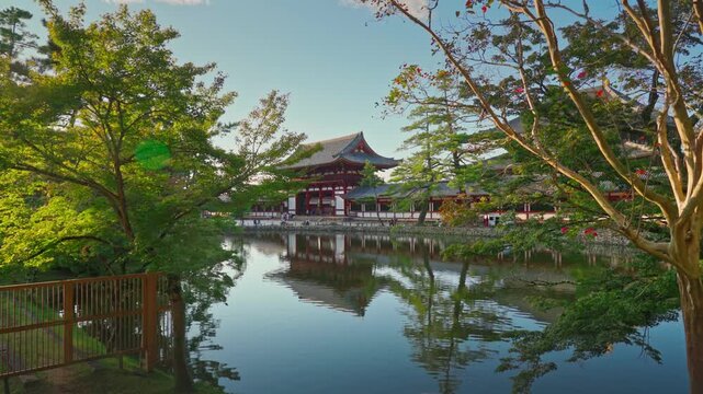Nara, Japan - Sep 26 2024, 4k, Panoramic view across the pond and trees to the facade of Todaiji Temple, Great Buddha Hall, with a blue cloudy sky, Nara, Japan