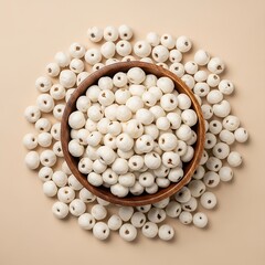 ​A top-down view of white roasted makhana seeds in a wooden bowl over a neutral beige background.