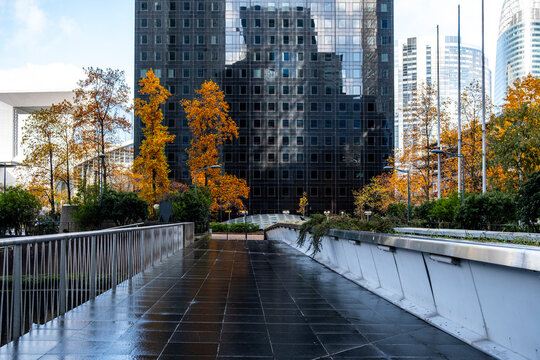 Autumn urban walkway under modern architecture skyline in La Defense Paris corporate district with office towers and contemporary cityscape