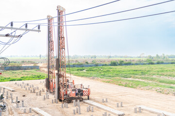 Industrial piling rig installing concrete pillars for a deep building foundation.
