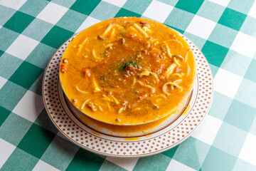 ひき肉の旨味が溶け出したソースにパスタを合わせた, ボロネーゼのスープパスタ。熱々のスープと麺が絡み合う様子や, 冬の温かメニュー, イタリアンレストランの新作を伝える販促・広告用素材に。 | a bolognese soup pasta with savory ground meat sauce and noodles in a warm broth.