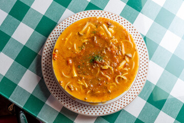 ひき肉の旨味が溶け出したソースにパスタを合わせた, ボロネーゼのスープパスタ。熱々のスープと麺が絡み合う様子や, 冬の温かメニュー, イタリアンレストランの新作を伝える販促・広告用素材に。 | a bolognese soup pasta with savory ground meat sauce and noodles in a warm broth.