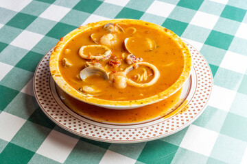 イカ、タコ、アサリ、ホタテを贅沢に使い、魚介の出汁が溶け出したシーフードのトマトソーススープパスタ。色鮮やかなトマトスープと豊富な具材が絡み合う、イタリアンレストランの看板メニューや冬の温製パスタを伝える販促・広告用素材に。 | A seafood tomato sauce soup pasta with squid, octopus, clams, and scallops in a rich 