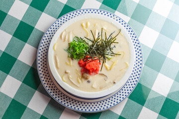 明太子、大葉、刻み海苔を添え、クリーミーな和風ホワイトソースにパスタを合わせた一皿。明太子のつぶつぶ感と薬味のアクセント、和洋折衷の優しい味わいを伝えるランチやディナーメニューの販促・広告用素材に。 | A Mentaiko (cod roe) and white sauce pasta topped with Shiso leaves and shredded Nori seaweed.