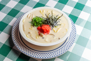 明太子、大葉、刻み海苔を添え、クリーミーな和風ホワイトソースにパスタを合わせた一皿。明太子のつぶつぶ感と薬味のアクセント、和洋折衷の優しい味わいを伝えるランチやディナーメニューの販促・広告用素材に。 | A Mentaiko (cod roe) and white sauce pasta topped with Shiso leaves and shredded Nori seaweed.