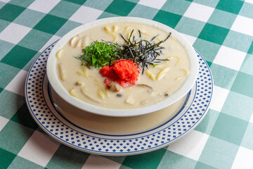 明太子、大葉、刻み海苔を添え、クリーミーな和風ホワイトソースにパスタを合わせた一皿。明太子のつぶつぶ感と薬味のアクセント、和洋折衷の優しい味わいを伝えるランチやディナーメニューの販促・広告用素材に。 | A Mentaiko (cod roe) and white sauce pasta topped with Shiso leaves and shredded Nori seaweed.