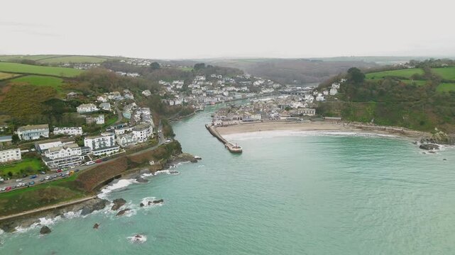 Sideways aerial view of Looe harbour and coastal town in Cornwall