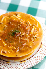 ひき肉の旨味が溶け出したソースにパスタを合わせた, ボロネーゼのスープパスタ。熱々のスープと麺が絡み合う様子や, 冬の温かメニュー, イタリアンレストランの新作を伝える販促・広告用素材に。 | a bolognese soup pasta with savory ground meat sauce and noodles in a warm broth.