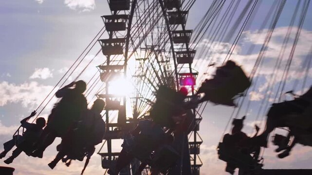 Traditional Bavarian folk festival Oktoberfest in Munich with famous rides Wellenflug swing carousel and Willenborgs Riesenrad Ferris wheel. Family fun and German culture at the Theresienwiese