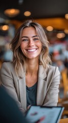 Fototapeta premium Smiling young woman in a blazer looking at the camera in a professional setting