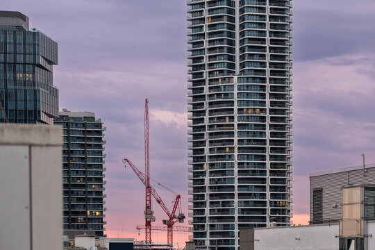 Dusk urban skyline with crane and modern skyscraper building showing construction industry work and architecture during twilight development phase